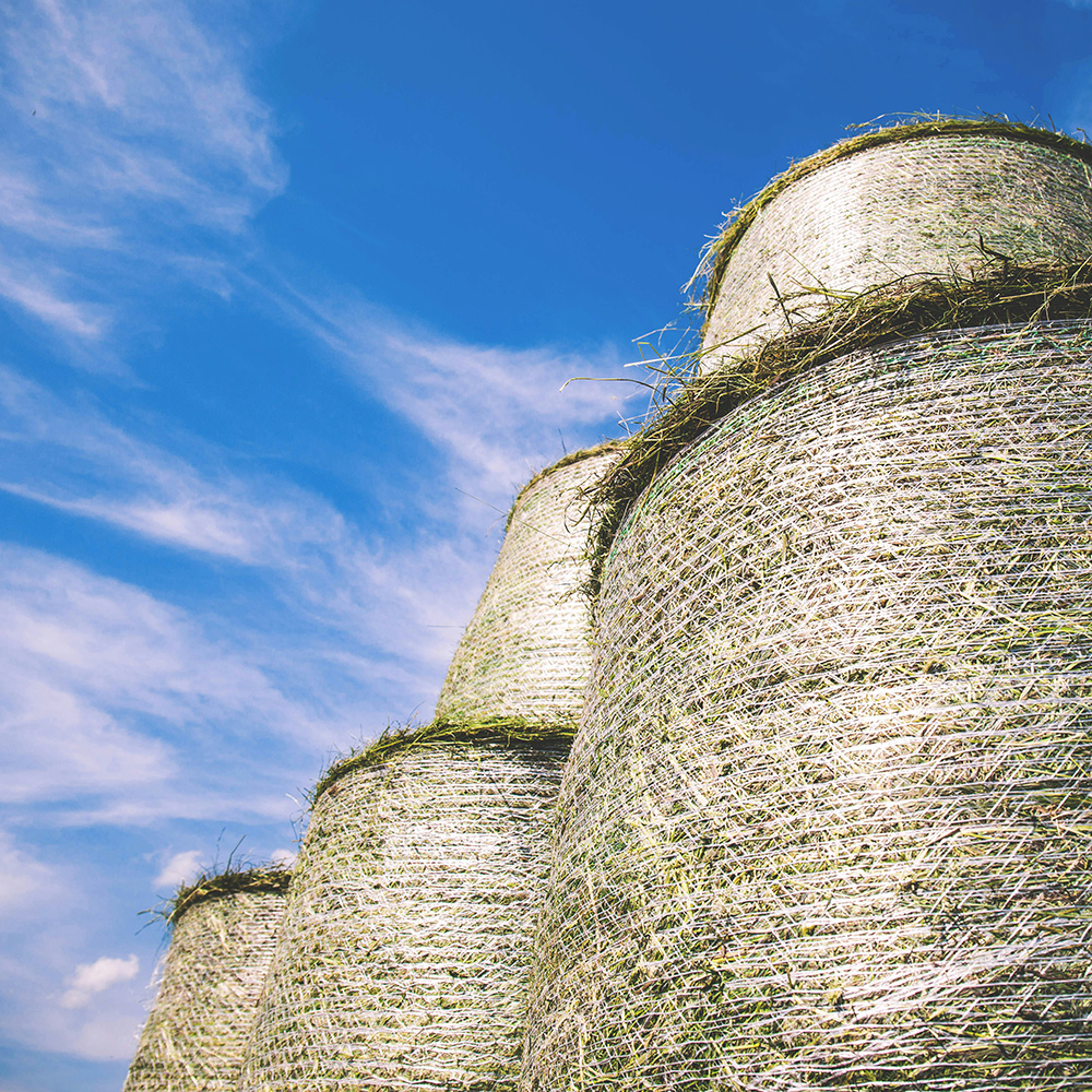 Photo of wrapped and stacked round hay bales by freestocks on Unsplash